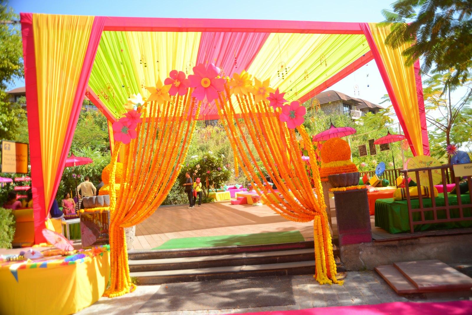 A draped mehendi mandap in marigold, saffron and rose